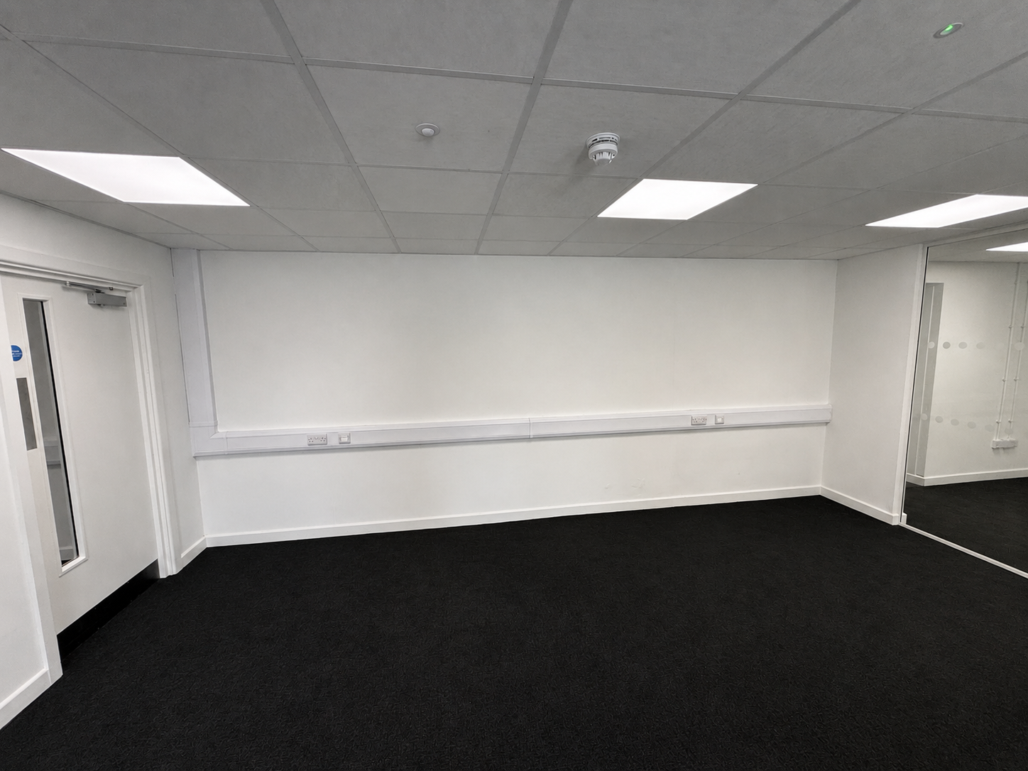 Commercial fit-out showing lighting, fire detection and dado trunking